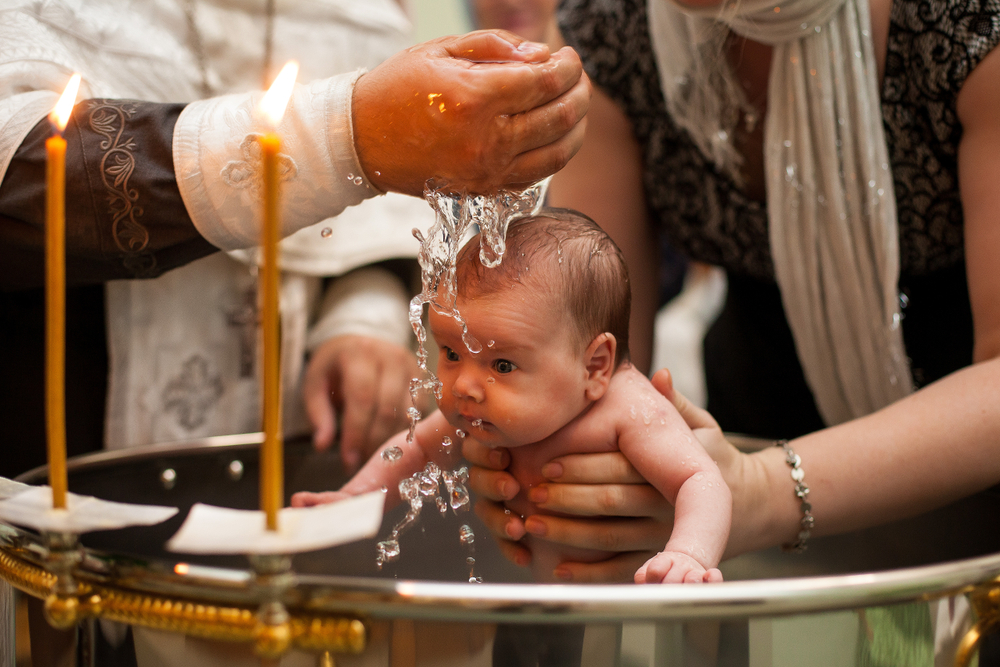 Newborn baby baptism in Holy water